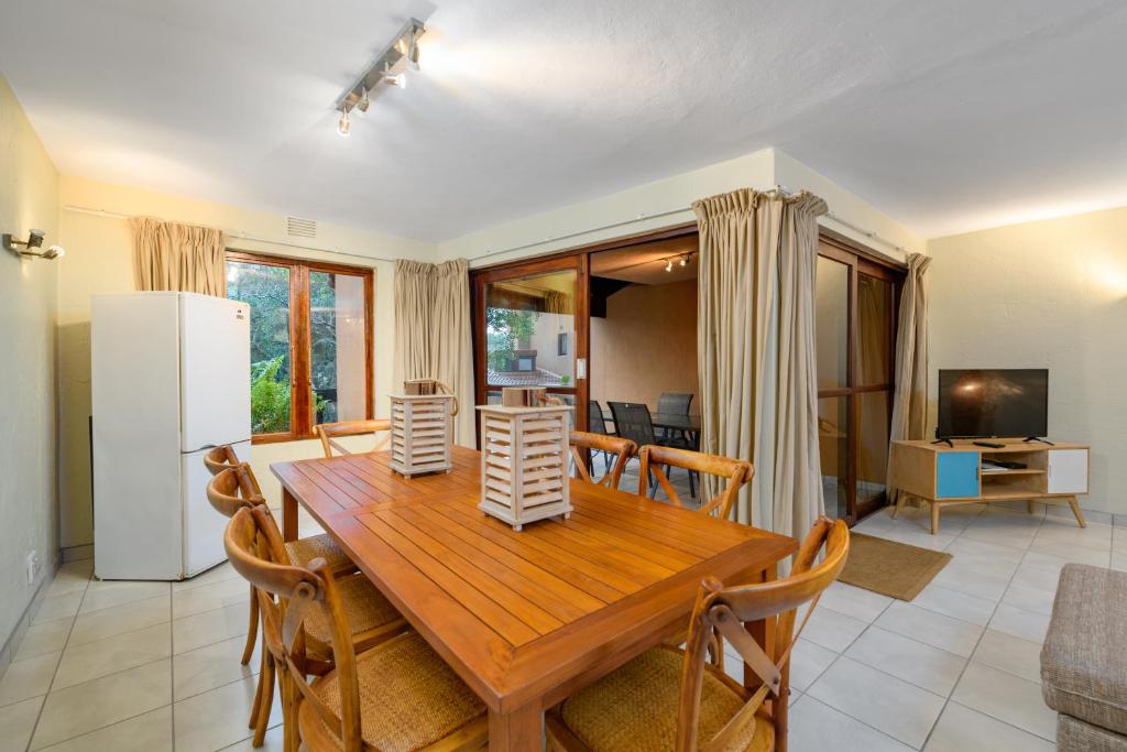 a kitchen and dining room with a wooden table and chairs at San Lameer Villa 3014 - 3 Bedroom Classic - 6 pax - San Lameer Rental Agency in Southbroom