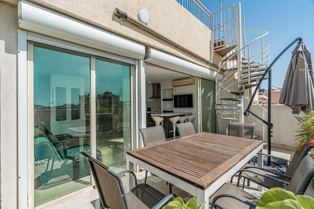 um pátio com uma mesa e cadeiras numa varanda em Penthouse 3BR in Ben Yehuda By Holiday Rentals em Tel Aviv