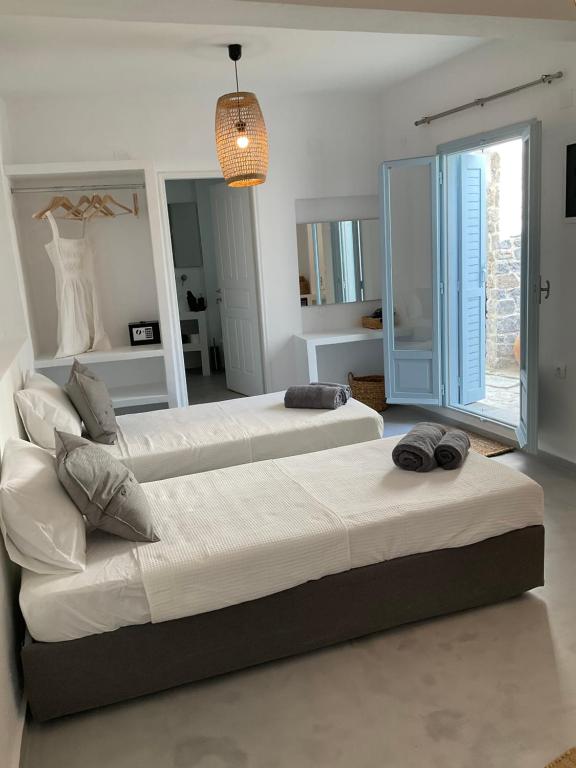 2 bedden in een slaapkamer met een groot raam bij Okeanos in Skiathos-stad