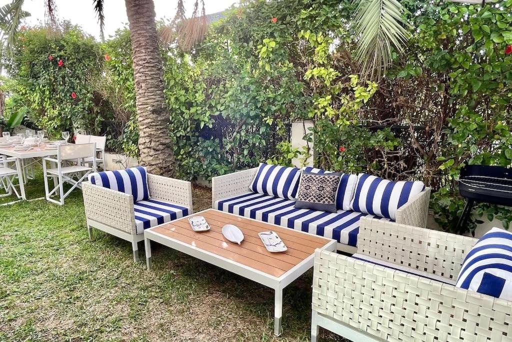 un patio con mesa y sofás de rayas azules y blancas en Sindbad House, en La Marsa
