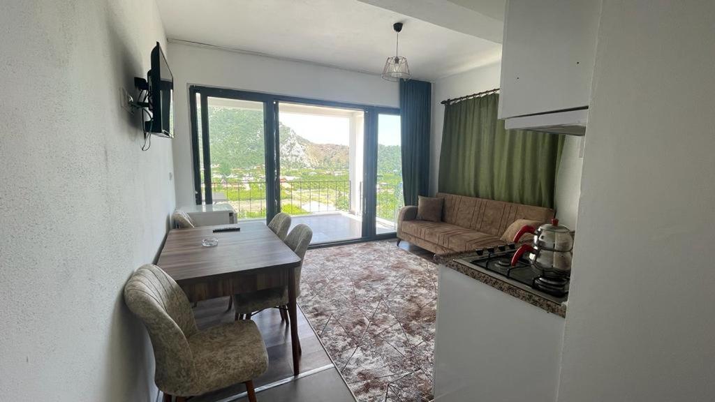 cocina y sala de estar con mesa y sofá en Öz Akdeniz Apart, en Kumluca