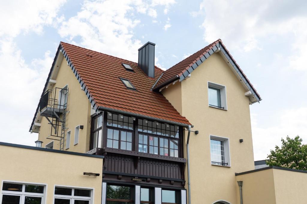 une maison avec un toit rouge dans l'établissement Boutique Hotel & Location Cham, à Meerbusch