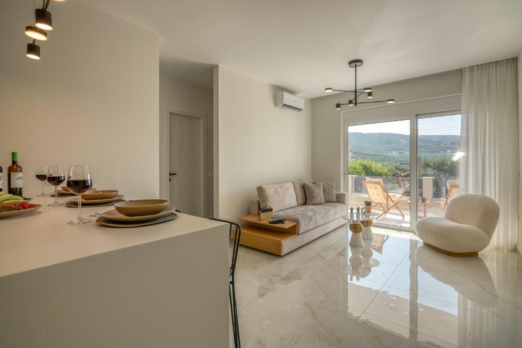 ein weißes Wohnzimmer mit einem Sofa und einem Tisch in der Unterkunft Villenia Luxury Apartments in Kissamos