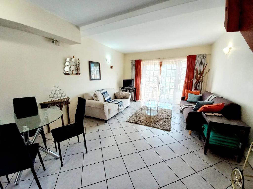 a living room with a couch and a table at 57 Settler Sands Beach Apartment in Port Alfred