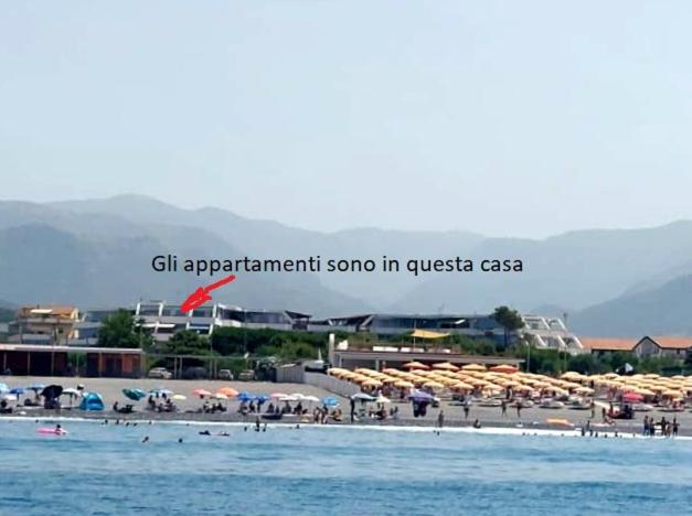 een strand met parasols en mensen op het strand bij L' appartamento dista 2 minuti a piedi dal mare! in Scalea
