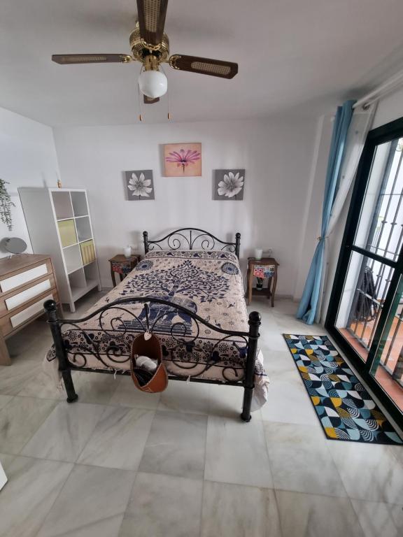 - une chambre avec un lit et un ventilateur de plafond dans l'établissement Quilla Apartment, à Torrequebrada