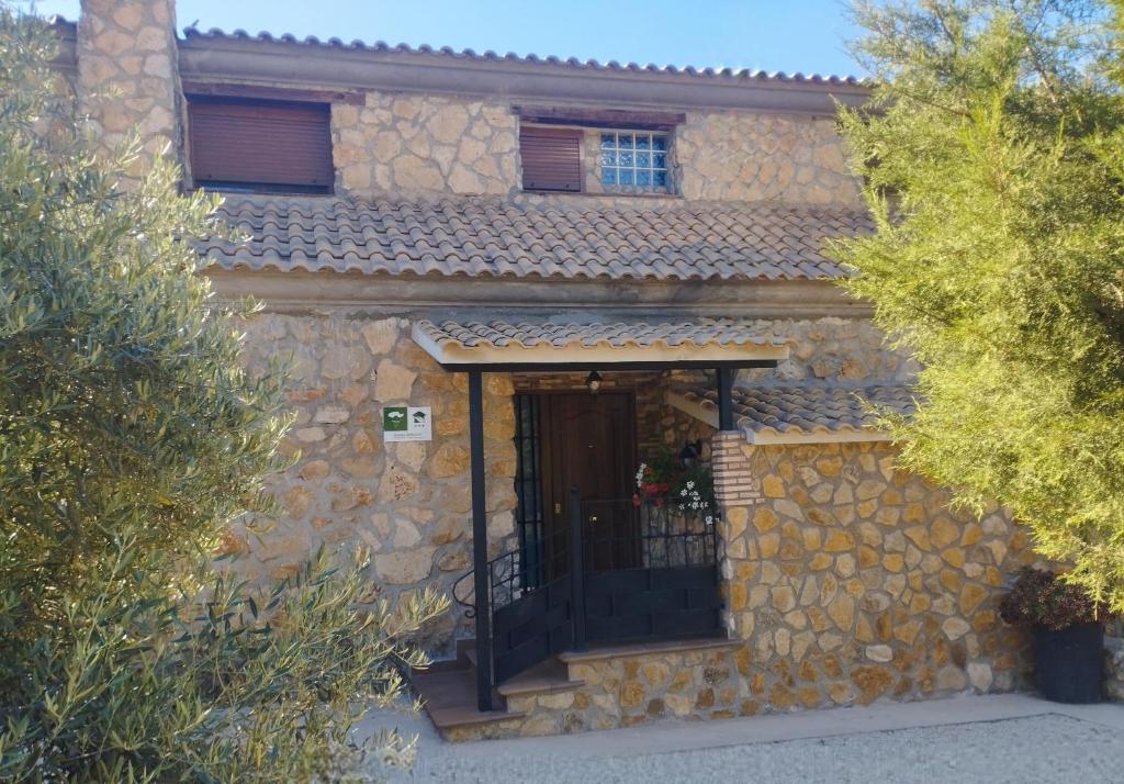 une maison en pierre avec une porte en face dans l'établissement Haza Del Puente, à Riópar