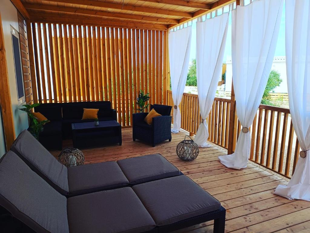 un soggiorno con divano e tende su una terrazza di Mobile Home Drage a Drage
