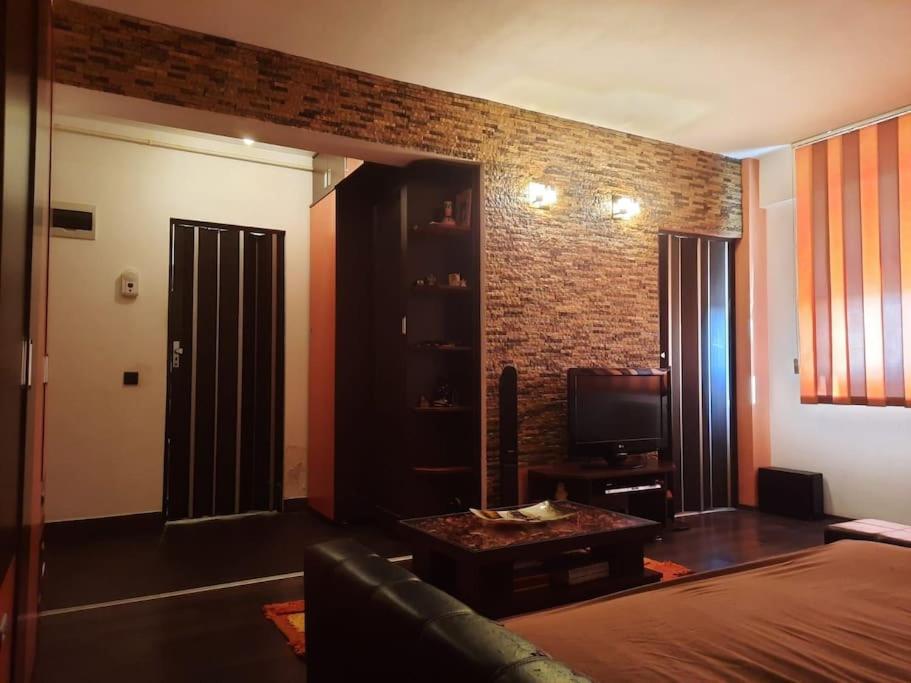 - un salon avec un canapé et un mur en briques dans l'établissement Apartament cu parcare privata, à Arad