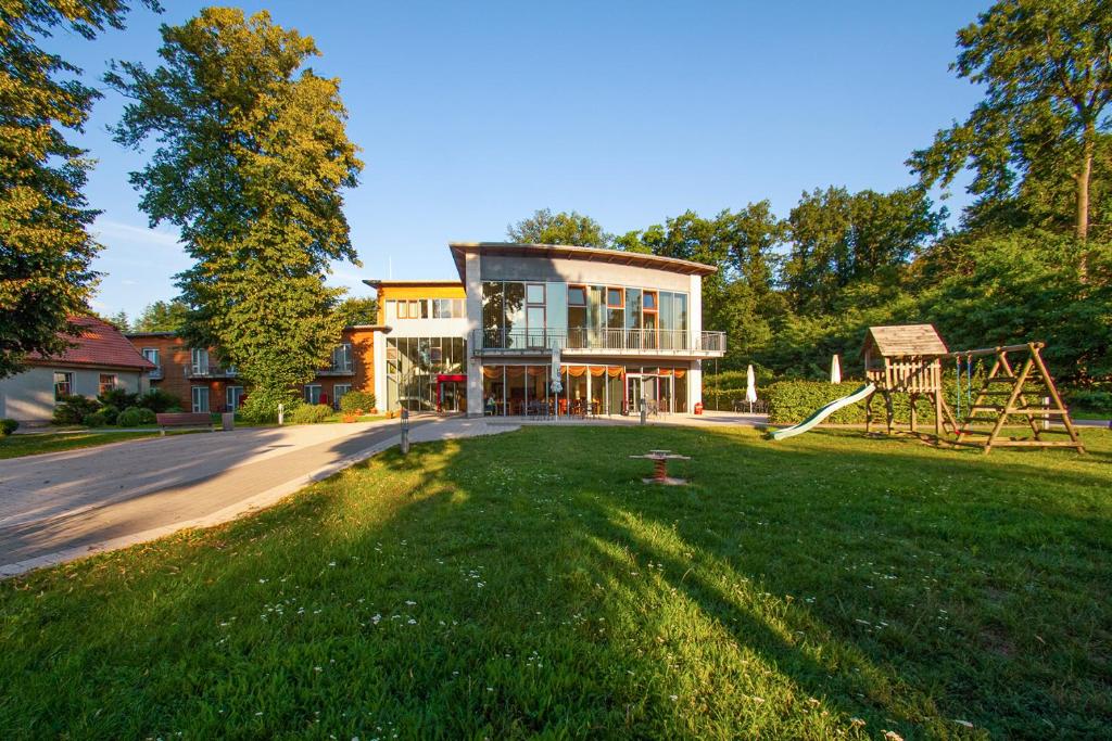 ein Haus mit einem großen Garten mit Spielplatz in der Unterkunft Ferienpark Plauer See in Alt Schwerin