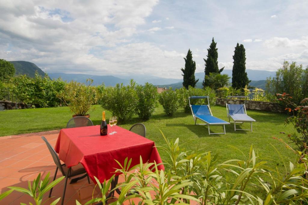 een tafel met een rood tafelkleed en twee blauwe stoelen bij Weingut Lieselehof Apt Aurora in Caldaro