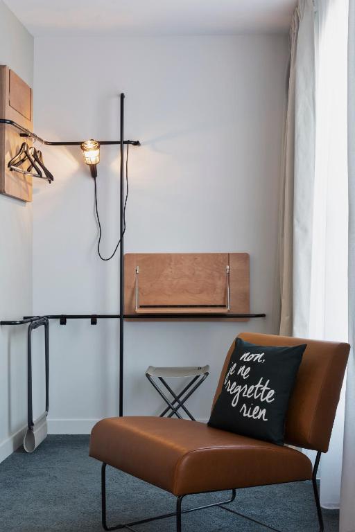 a chair with a pillow on it in a room at Moxy Paris Bastille in Paris