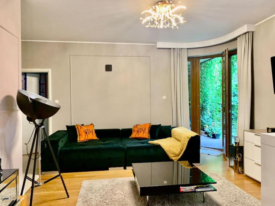 a living room with a green couch and a chandelier at Gdansk 300m od plaży in Gdańsk