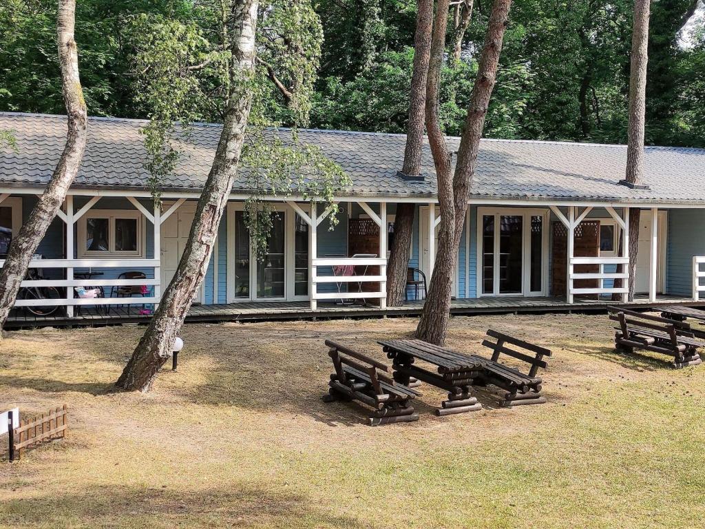 a house with picnic tables in front of it at Holiday house near the sea in Pobierowo for 4 people in Pobierowo
