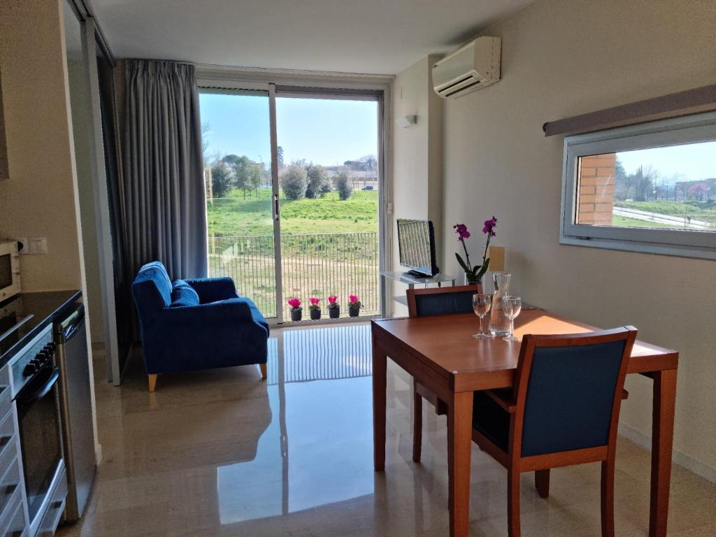ein Wohnzimmer mit einem Tisch, Stühlen und einem Fenster in der Unterkunft Apartaments Els Quimics in Girona