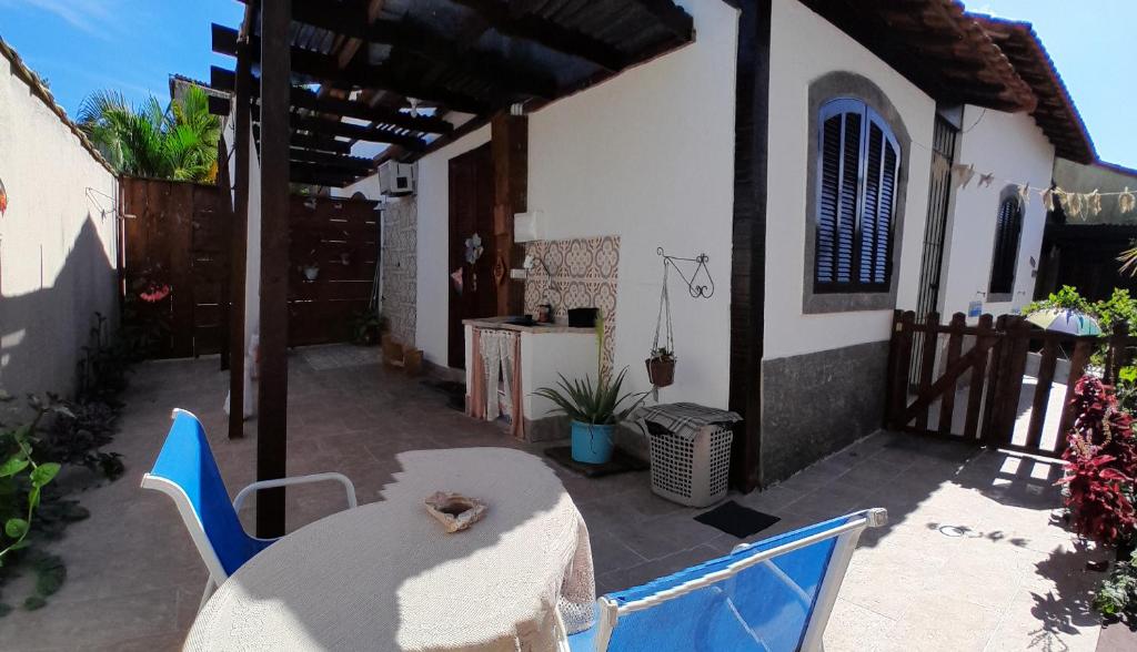 una casa y un patio con mesa y sillas en Suite Privativa Lar e Aconhego, en Maricá