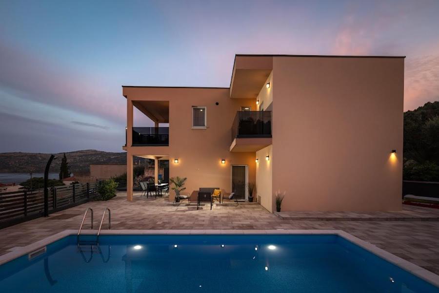 a house with a swimming pool in front of it at Apartman Avila in Marina