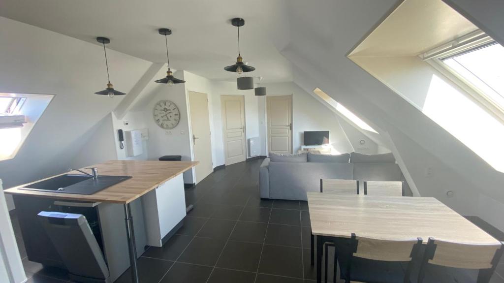 a kitchen with a sink and a table in a room at L’apparté, meublé de tourisme in Saint-Folquin