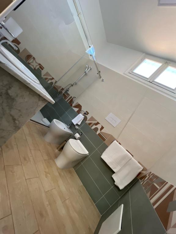 bagno con due servizi igienici e tavolo con sedie di 38 Aira Hotels a Palermo