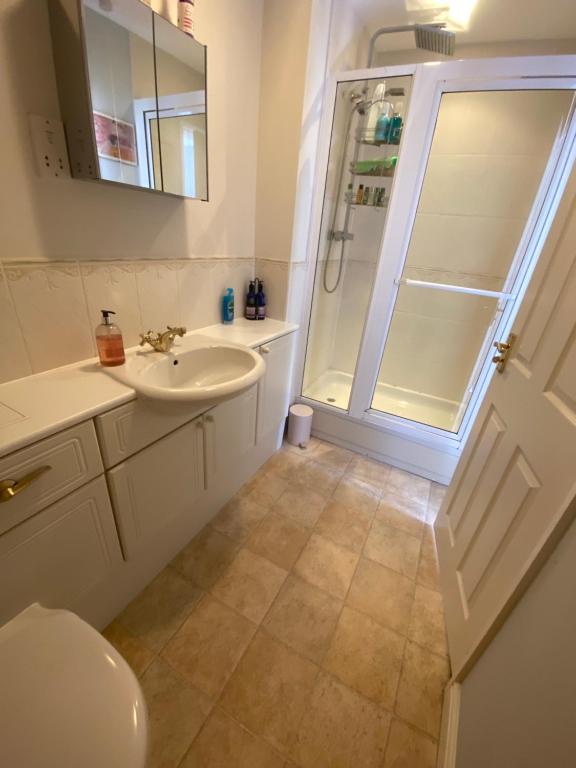 a white bathroom with a sink and a shower at Two double bedrooms in Paddock Wood in Paddock Wood