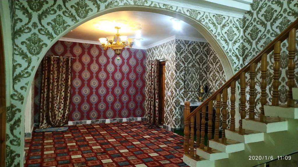 un pasillo con una lámpara de araña y escaleras en una casa en Coachman HomeStay, en Srinagar