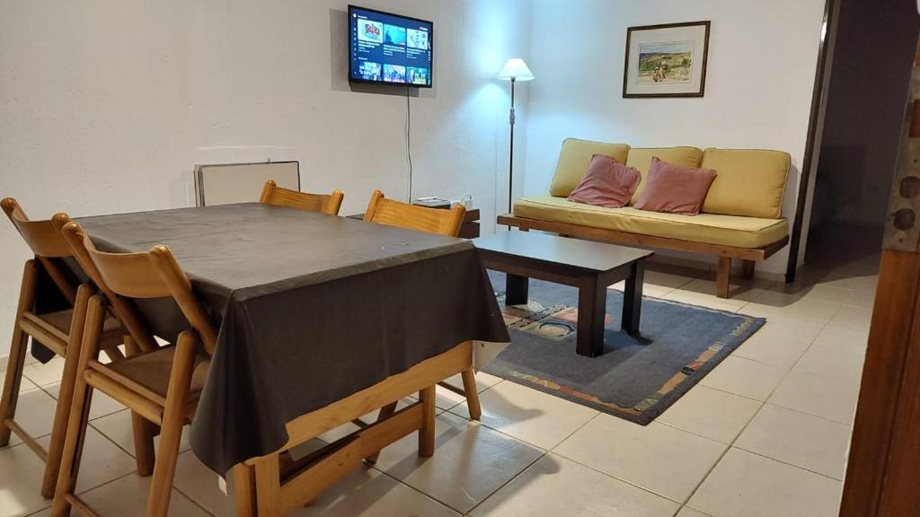 een woonkamer met een tafel en een bank bij DEPARTAMENTO RENATO in Godoy Cruz