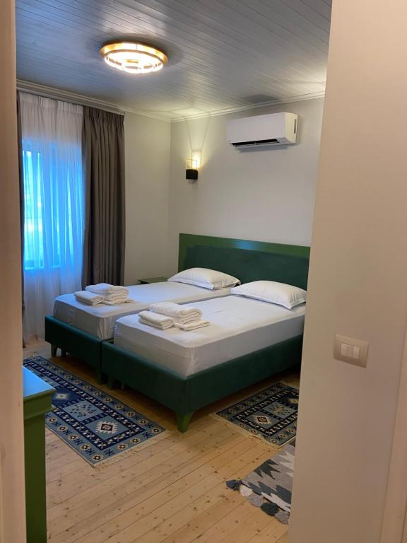 a bedroom with a bed with white sheets and a window at “Sarajet” Bed&Breakfast in Këlcyrë