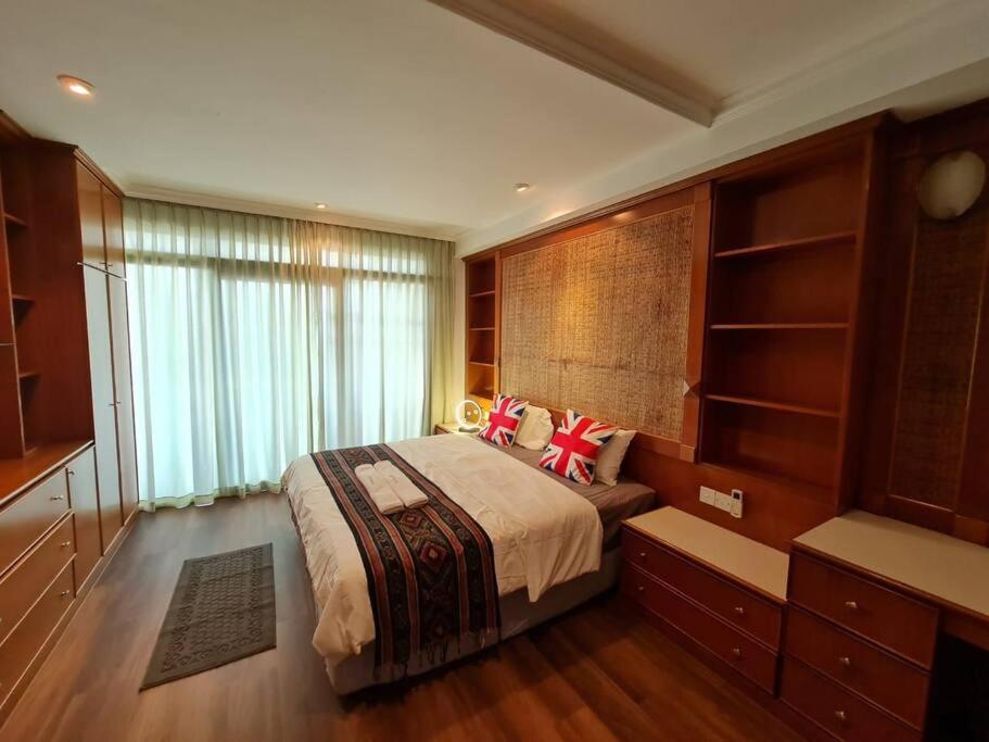 um quarto com uma cama grande e uma janela grande em Lovely Waterfront Riverbank Suite with Pool A2 em Kuching
