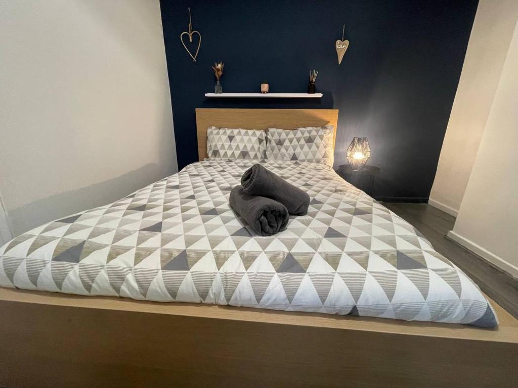 ein großes Bett mit einer schwarzen und weißen Bettdecke in der Unterkunft Joyous Private Room in City Centre in Liverpool