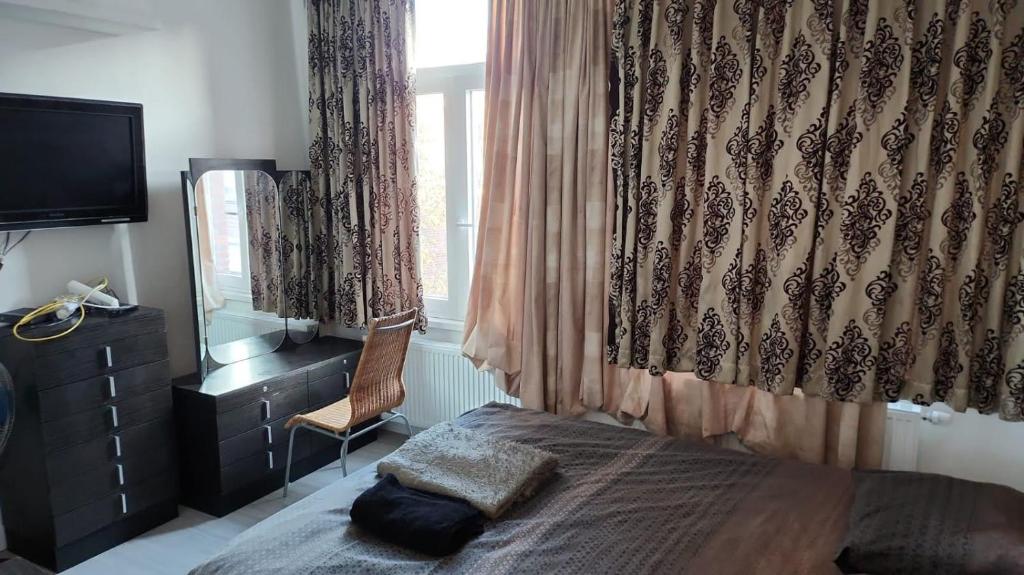 een slaapkamer met een bed, een dressoir en een raam bij Mechelen Room living with host in Mechelen