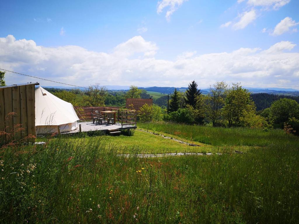 une tente blanche dans un champ d'herbe dans l'établissement Sous les Toiles de PauTiLou, à Molles