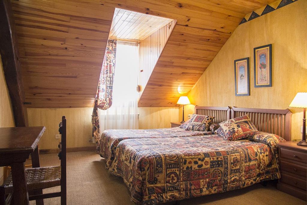 Dormitorio con cama y ventana en una cabaña en Casa rural Txikirrin II - Selva de Irati, en Villanueva de Aézcoa