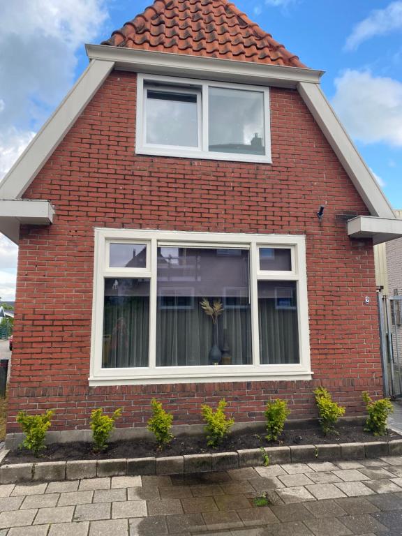 uma casa de tijolos vermelhos com janelas brancas em Free Fly Loft Drachten em Drachten