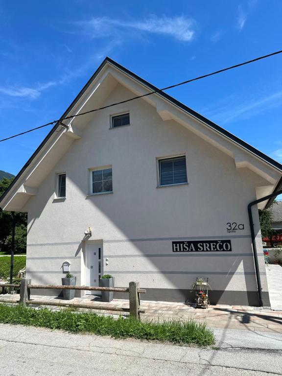 a white building with a sign on the side of it at Hiša Srečo in Begunje na Gorenjskem