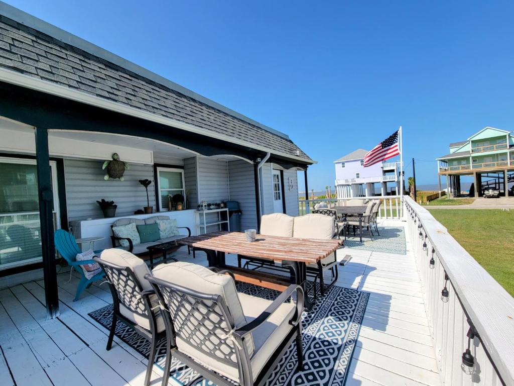 a deck with a table and chairs on a house at Sea-La-Vie, your beach house oasis in Freeport