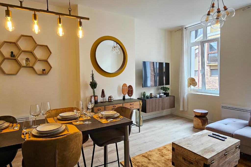 un soggiorno con tavolo da pranzo e specchio di Les Appartements de la Nef d'Or a Saint-Quentin