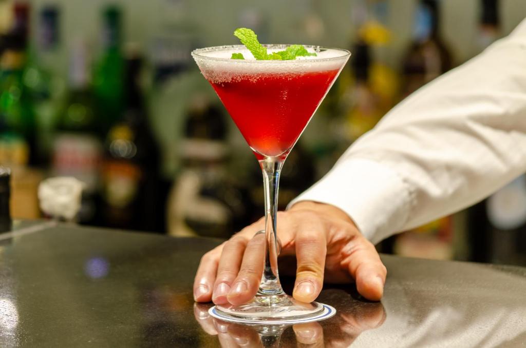 a person holding a red drink in a martini glass at Olissippo Marquês de Sá in Lisbon