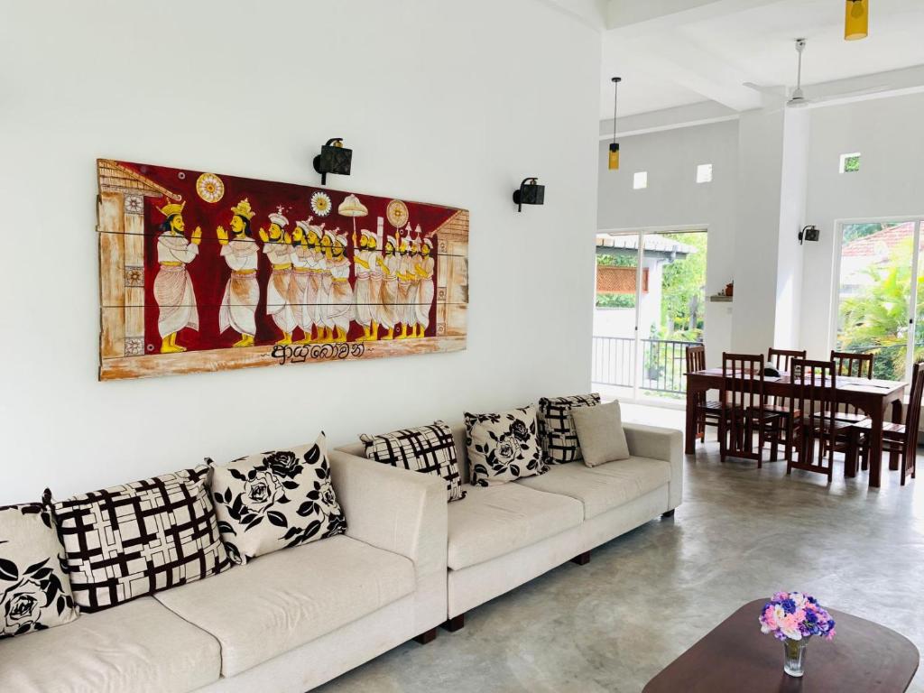 uma sala de estar com um sofá branco e uma pintura na parede em Everdew Kandy em Kandy