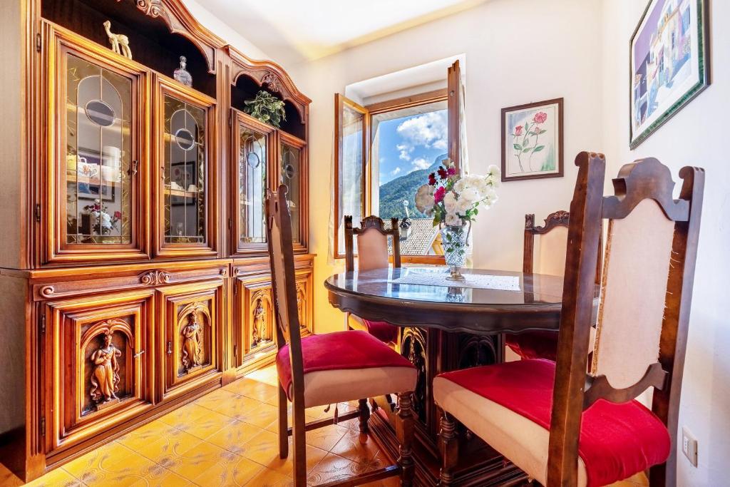 a dining room with a table and wooden hutch at Casa nel Borgo Rose in Breguzzo