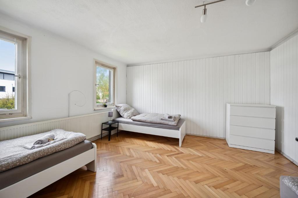 a white room with two beds and a window at home2stay worker Apartments Nürtingen-Zizishausen Ap1 in Nürtingen