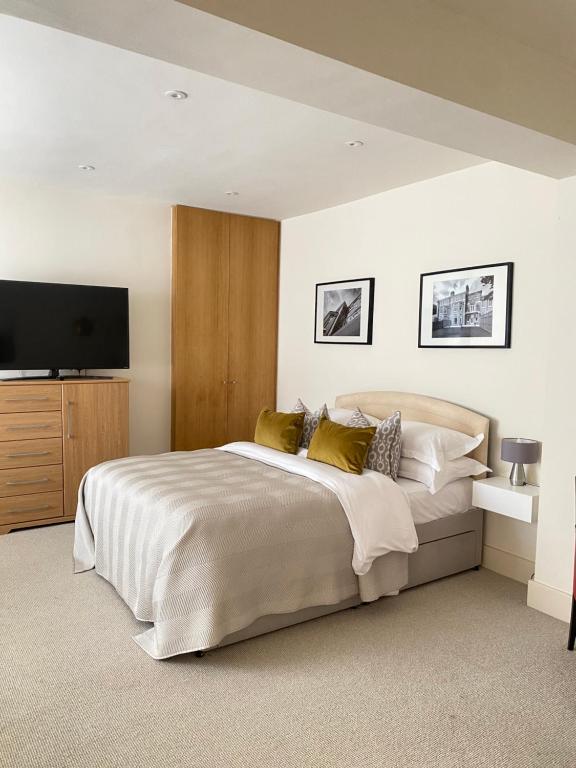 a bedroom with a large bed and a flat screen tv at Belgravia Apartments in London