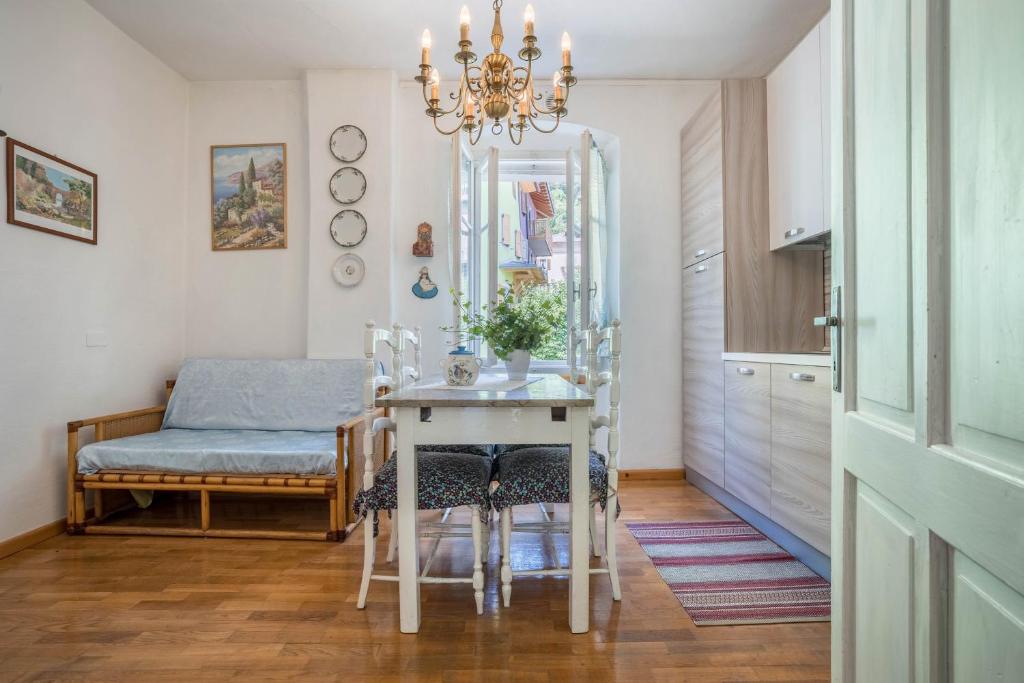 una sala da pranzo con tavolo e lampadario pendente di Casa nel Borgo Edera a Breguzzo