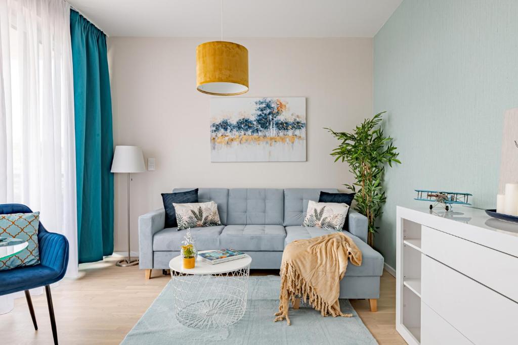 a living room with a blue couch and a table at Waterfront Luxury Residence - Paid Parking Option in Budapest