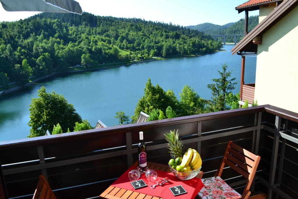 - une table sur un balcon avec vue sur la rivière dans l'établissement Madora - Studio Apartman, à Fužine