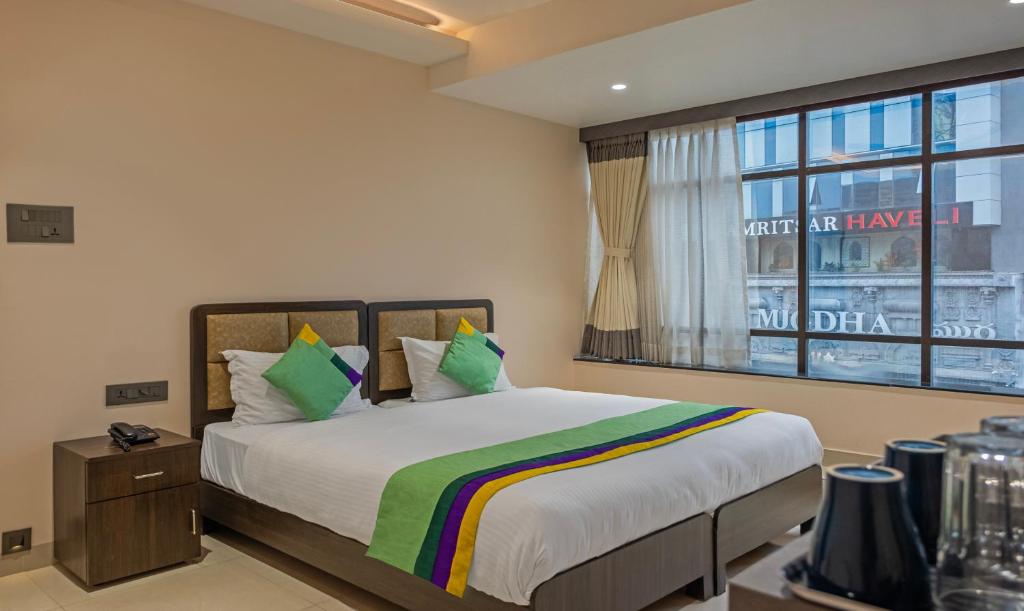 a bedroom with a large bed and a window at Treebo Su Casa Grand in Visakhapatnam