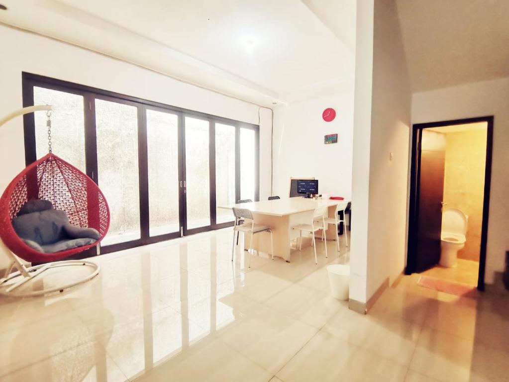 4-Bedroom Home in South Jakarta Nuansa Swadarma Residence by Le Ciel Hospitality في جاكرتا: غرفة معيشة مع كرسي معلق وطاولة