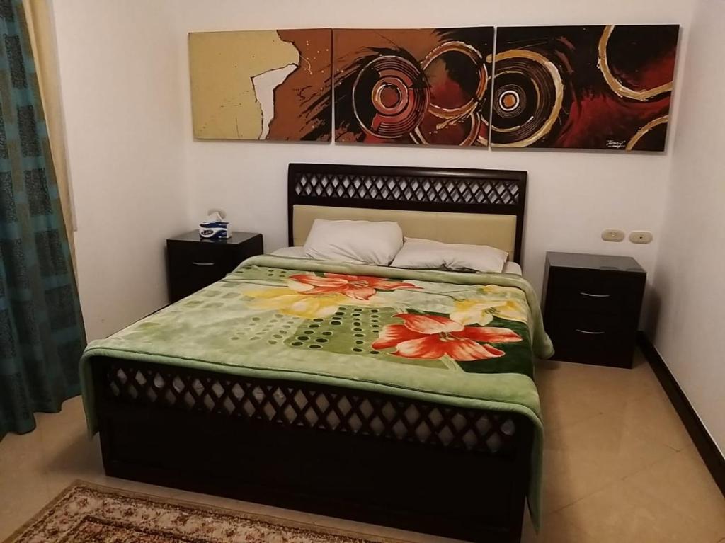 a bedroom with a bed with a flower blanket at شرم ستار مكتب رقم 230 in Sharm El Sheikh