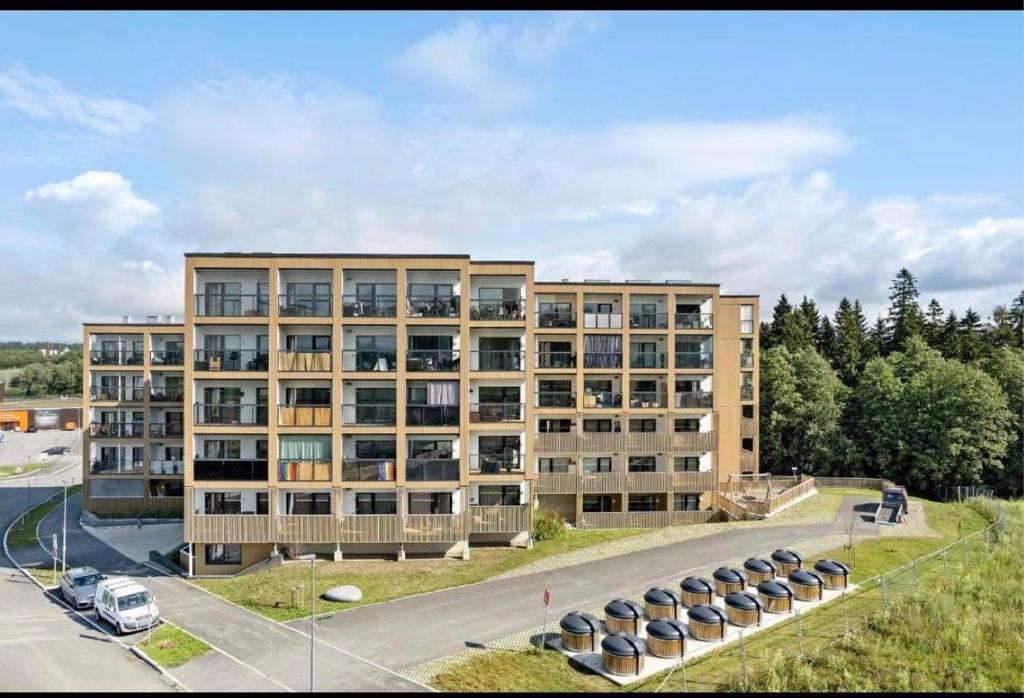 an apartment building with cars parked in a parking lot at Koselig studioleilighet in Jessheim