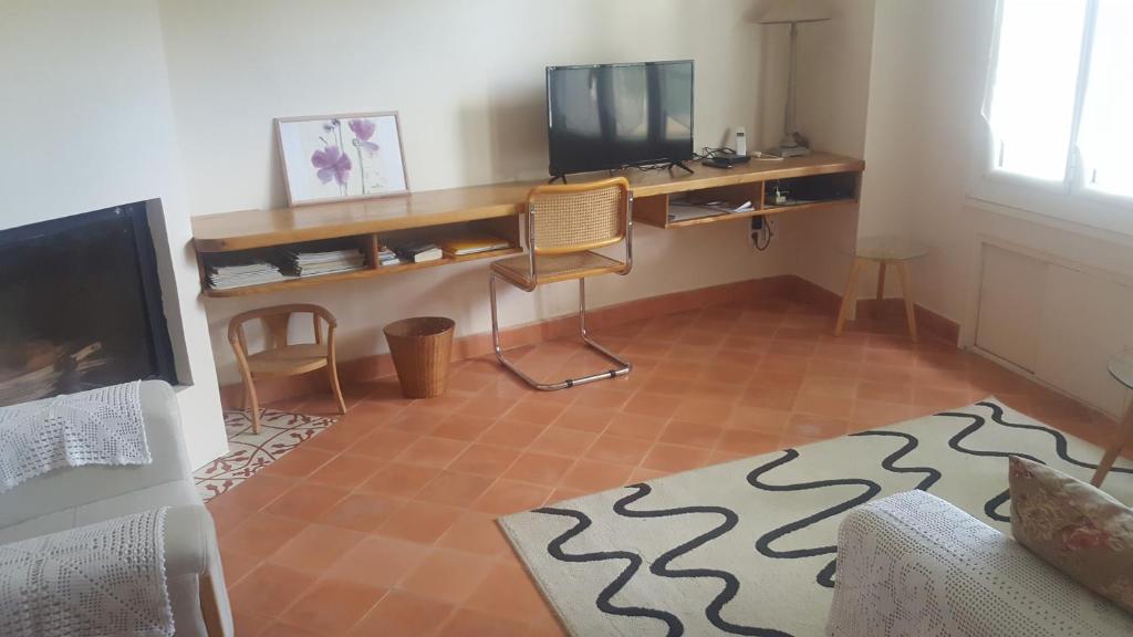 - un salon avec une télévision et un bureau avec une télévision dans l'établissement Maison de village, à Saint-Hilaire