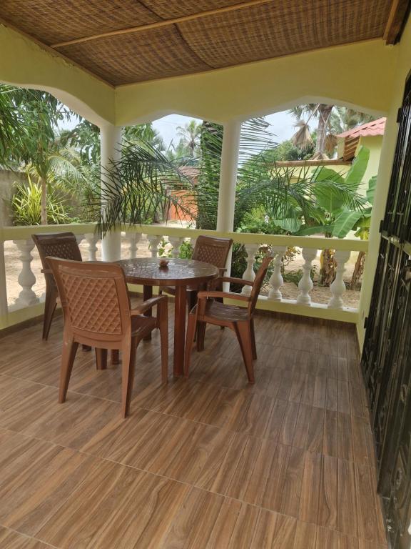 une salle à manger avec une table et des chaises sur une terrasse couverte dans l'établissement La Cazasamba, à Cap Skirring